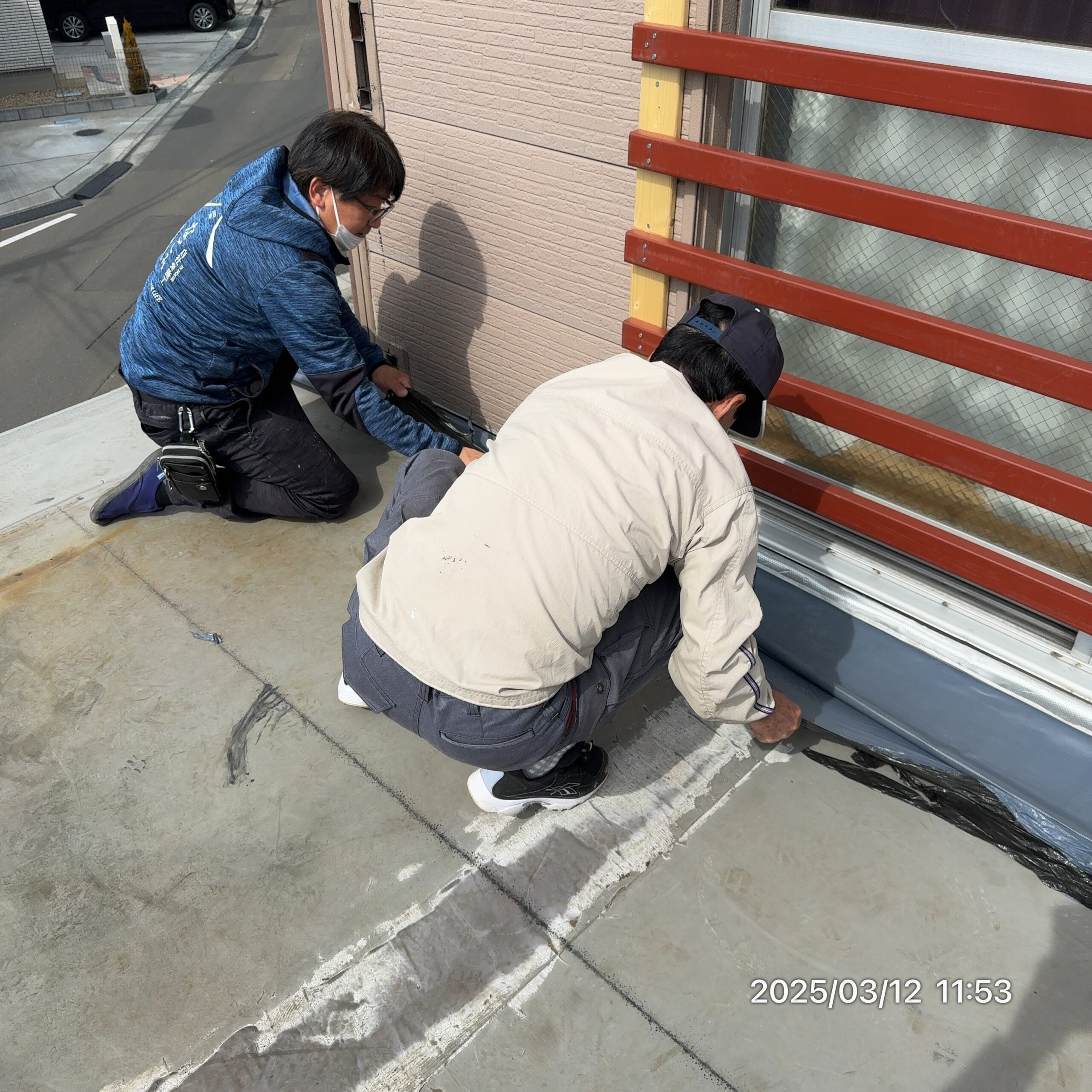 職人と並んで現場を確認する小野